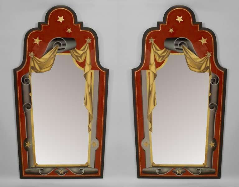 Pair of Italian eglomise wall mirrors set in ebonized wood frames. Beneath shaped pediment tops, each mirror is painted with gold stars and a trompe l'oeil image of a golden curtain draped over a grey, scrolling frame (Modern).