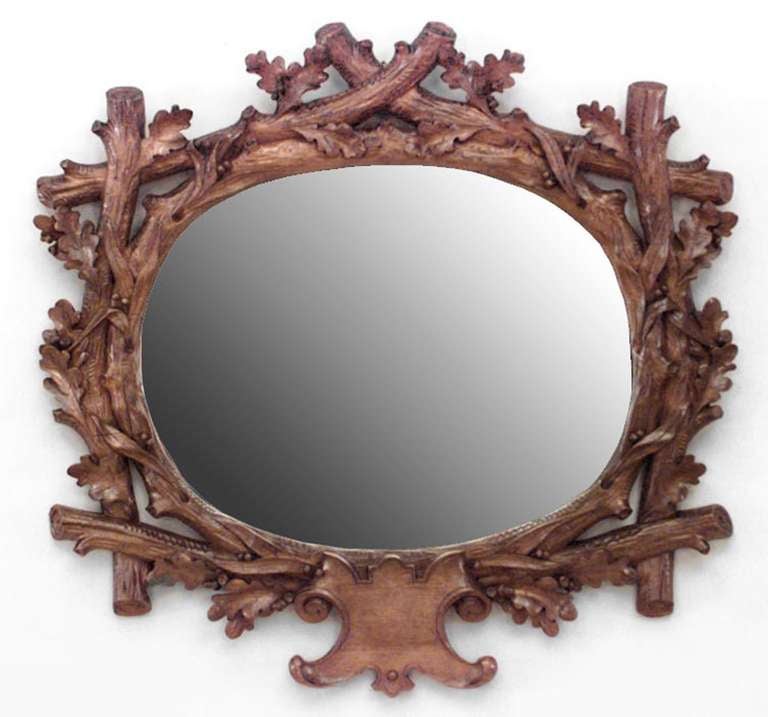 Nineteenth century oval shaped mirror composed of oak with carved oak lead and twig designs around bevelled glass.