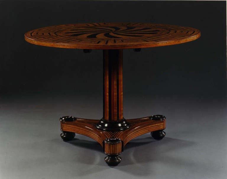 Italian Neo-classic (circa 1820) walnut center table with ebony & boxwood inlay having a round top with a Greek key border & spiral motif on an octagonal pedestal above a triform base.
