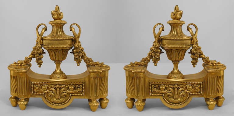 Ein Paar französische Bronze-Andirons im Louis XVI-Stil (19. Jahrhundert) mit einer Urne in der Mitte, die auf jeder Seite einen Griff mit einer Flammenblume hat. (PREIS ALS PAAR)
