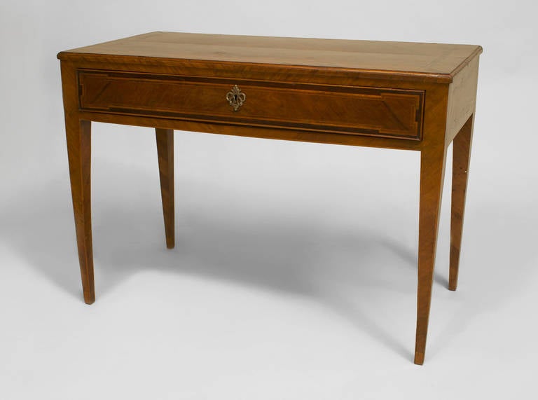 Late eighteenth or early nineteenth century Italian Neoclassic walnut table desk with four square tapered legs and one large drawer beneath a rectangular top inlaid with geometric and banded designs also reflected on its sides.

For related