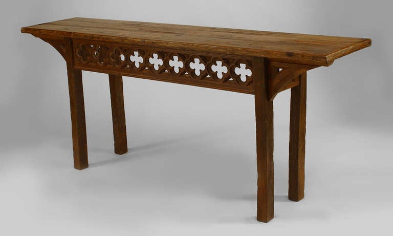 Late nineteenth or early twentieth century Gothic Revival narrow oak console table rectangular top joined to four square legs by a carved floral motif apron.