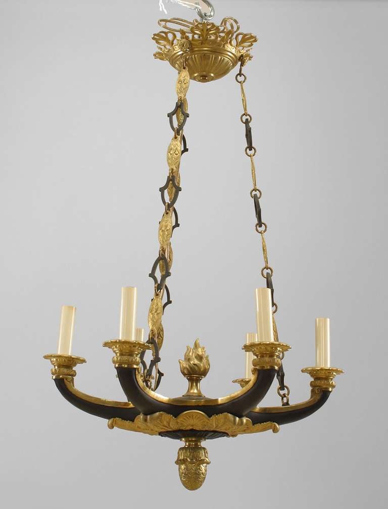 French Empire-style (19th Century) ebonized and gilt bronze 6 arm chandelier suspended by 3 black and gilt bronze link extensions with a flame finial top and acorn finial bottom.
