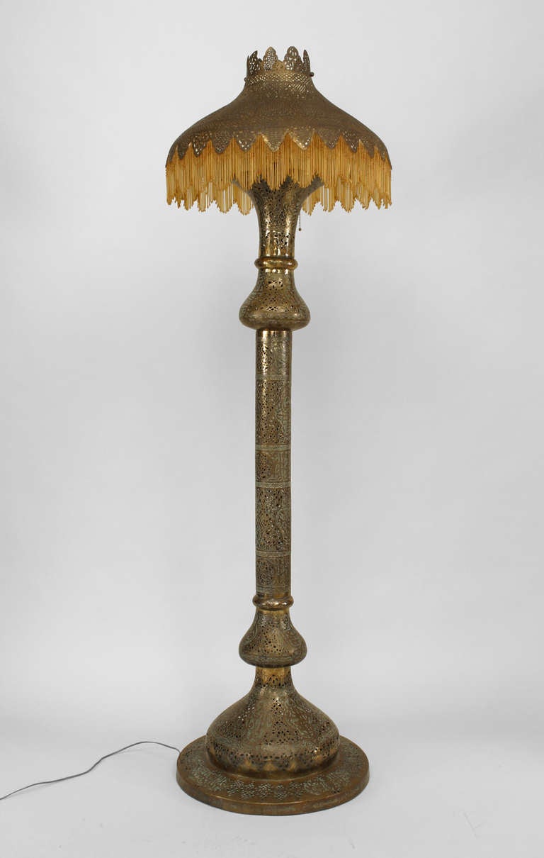 Middle Eastern Moorish style (19/20th Century) brass filigree floor lamp with amber glass beads hanging from shade.
