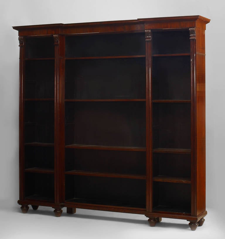 English William IV (circa 1840) mahogany 3 section bookcase with fluted and carved sides and section dividers and resting on ball feet.
