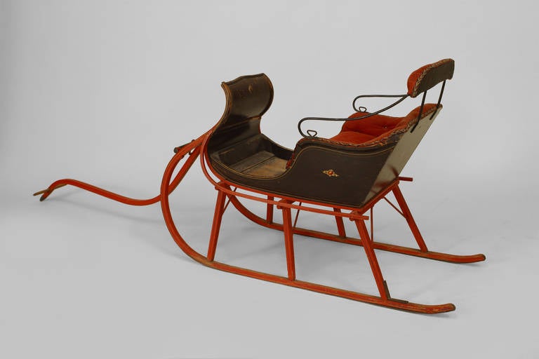 19th century American Country style red painted and black trimmed child's sleigh finished upholstered in tufted red fabric.