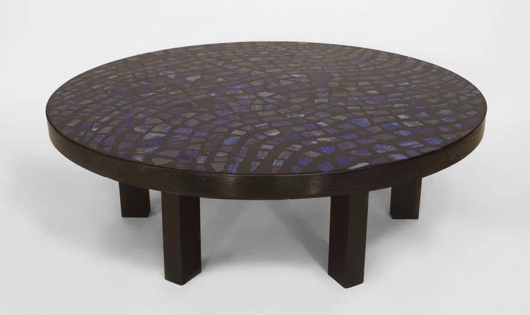 Signed E. Allemeersch, this 1970's Belgian round coffee table is composed of ebonized resin and is inset with lapis lazuli stones above six ebonized legs.