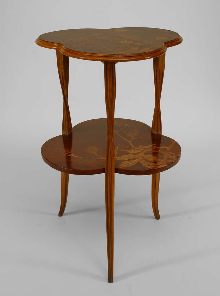 Inlaid walnut end table by noted French Art Nouveau designer Louis Majorelle. The table features a clover leaf shaped top and shelf framed by three twisting, vine-inspired legs.

For a similar piece, see dealer reference number 056364.