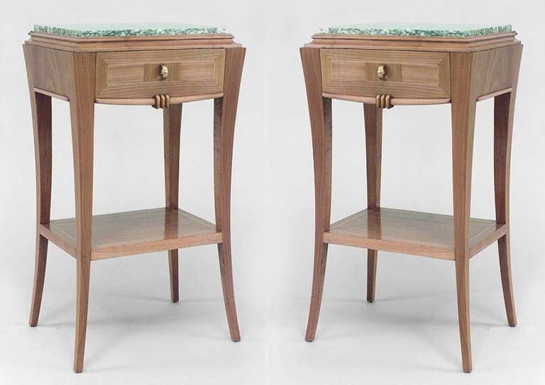 Attributed to French Art Deco designer Andre Frechet, this pair of cherrywood end tables features inset green marble tops above a drawer as well as four gently splayed legs and a lower shelf.
