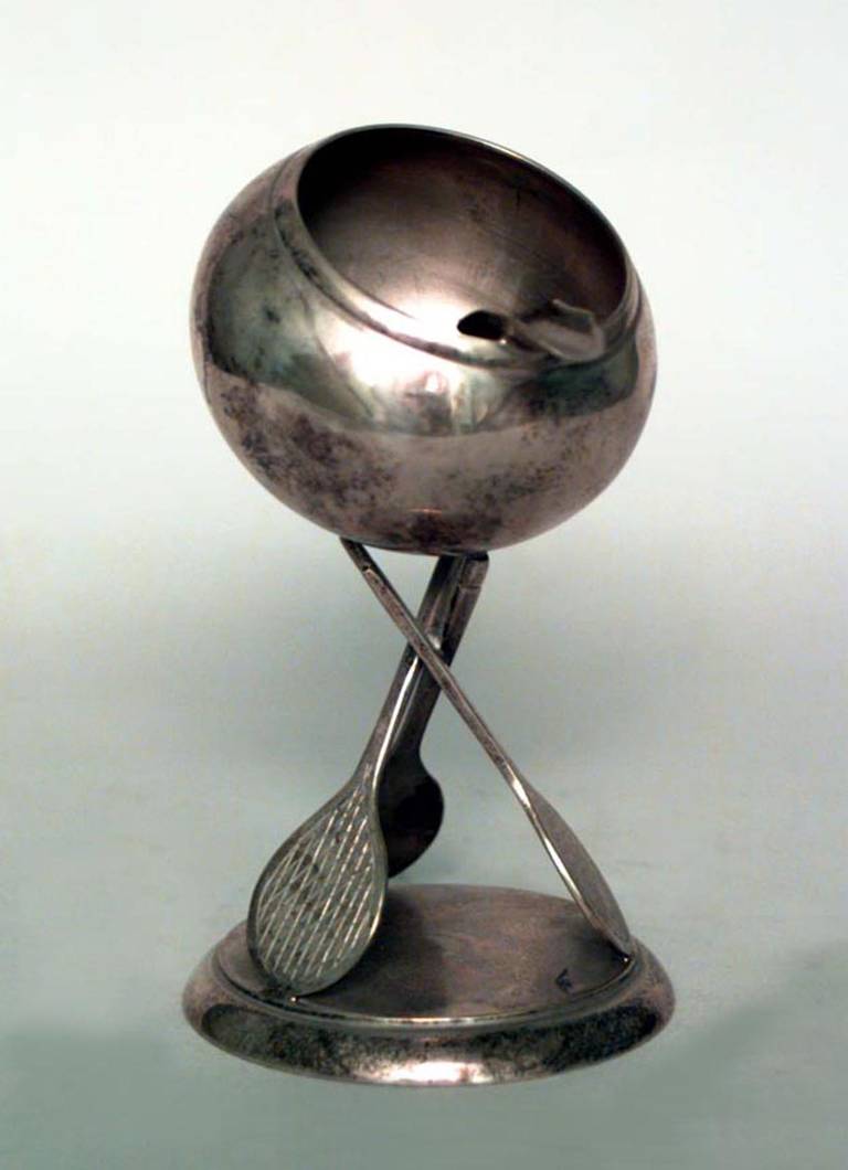 Zwei englische Art-Déco-Aschenbecher aus den 1920er oder 1930er Jahren aus versilbertem Metall, jeweils mit einem kugelförmigen Deckel, der auf drei Tennisschlägerstützen ruht.