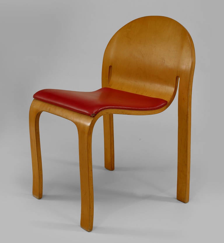 Twelve 1960's American Danko-labeled side chairs composed of plywood with round backs and red leather seats.