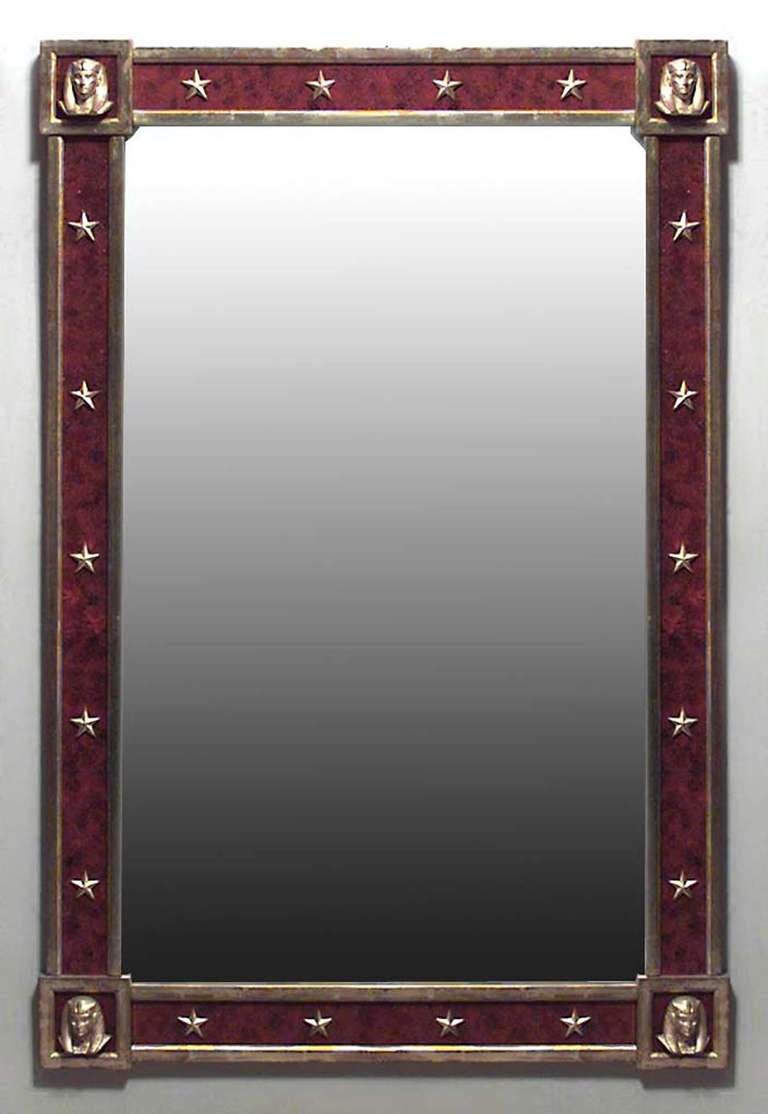 Pair of French Mid-Century (1940s) parcel gilt and red reverse painted glass wall mirrors with stars and Egyptian masks set to the slip and corners. (PRICED AS Pair)
