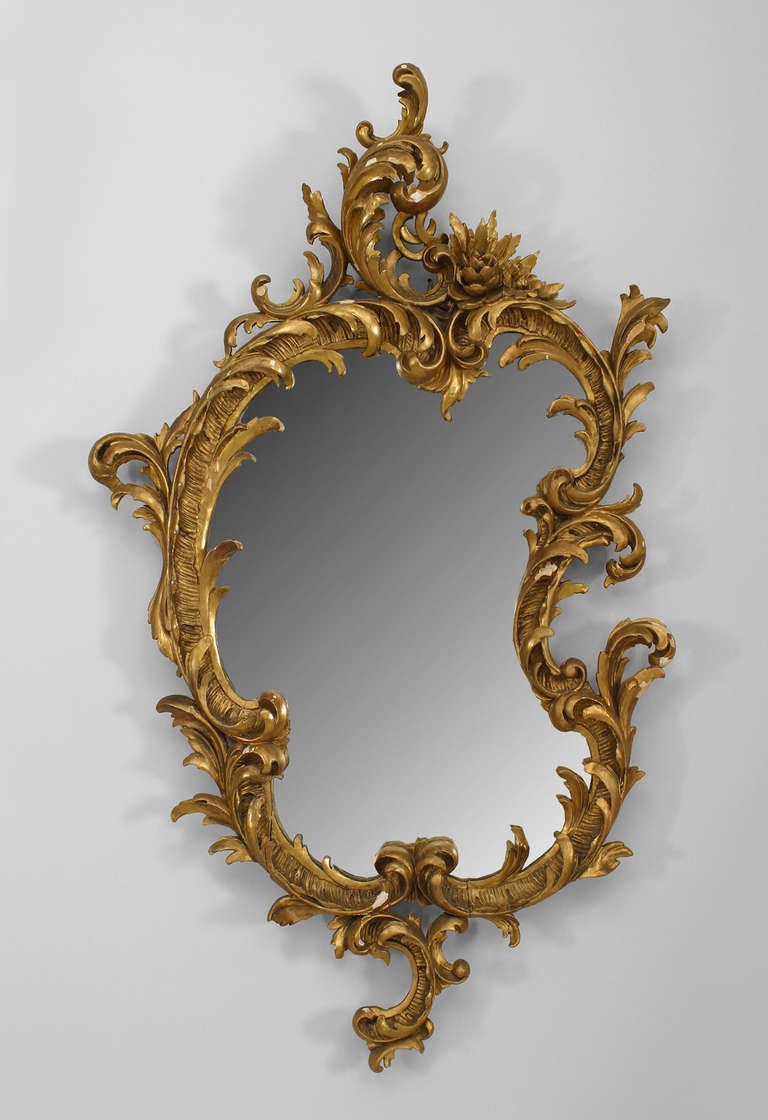 Nineteenth century French wall mirror with an irregular oblong form and a giltwood frame carved with scrolling foliate details.