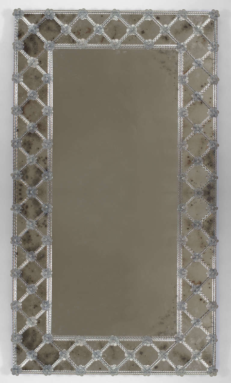Twentieth century rectangular murano glass wall mirror with an applied trellis design border composed of glass spindles and tinted blue glass flowers.