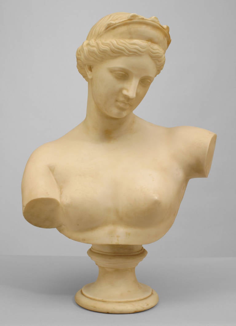 Turn of the Century Continental classicizing faux white marble bust depicting a nude, downward-glancing Grecian or Roman woman wearing a diadem in her hair.