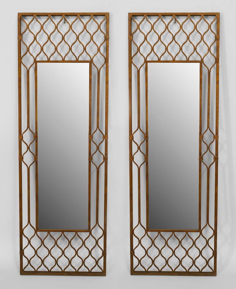 Pair of twentieth century Middle Eastern beveled wall mirrors set within rectangular frames of gold-painted latticed metal.