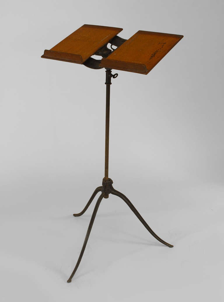 Nineteenth century American bookstand resting upon a thin, unadorned cast iron tripod stand with a rectangular oak top that folds in the form of a book with cast iron ornament.