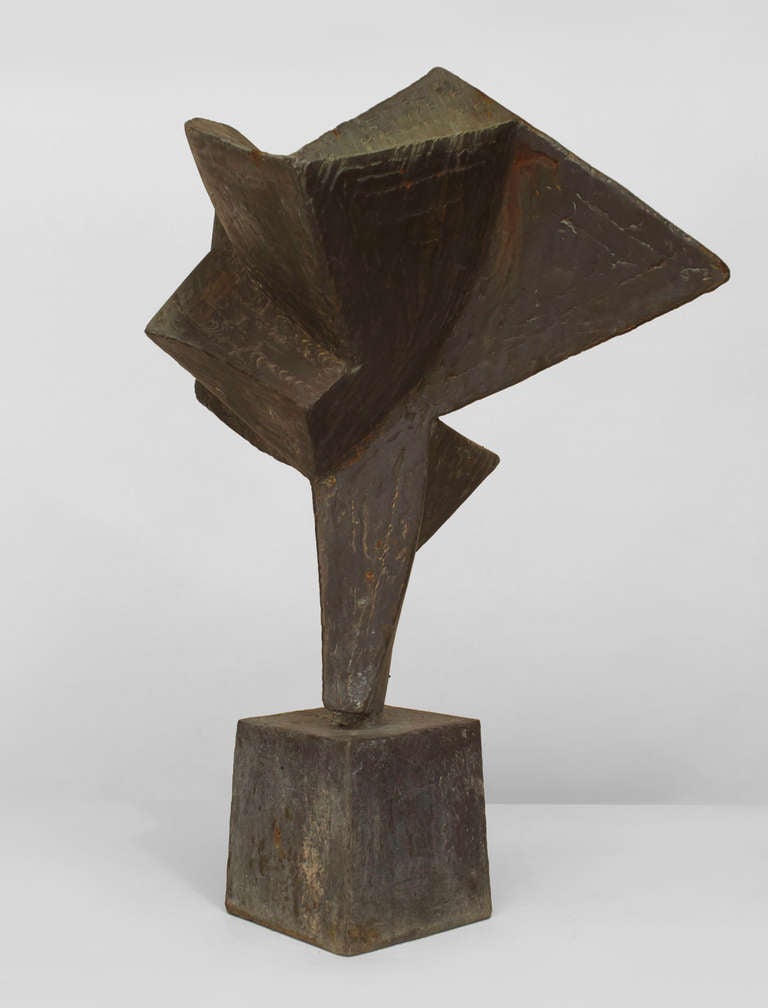 Mid-century American angular geometric form sculpture composed of welded steel with a grey/green patinated surface resting upon a tall tapered square base.
