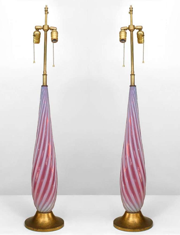 Pair of Italian 1940s Venetian Murano red and white Murano glass table lamps with swirl design and mounted on a round gilt wood base (PRICED AS Pair).

