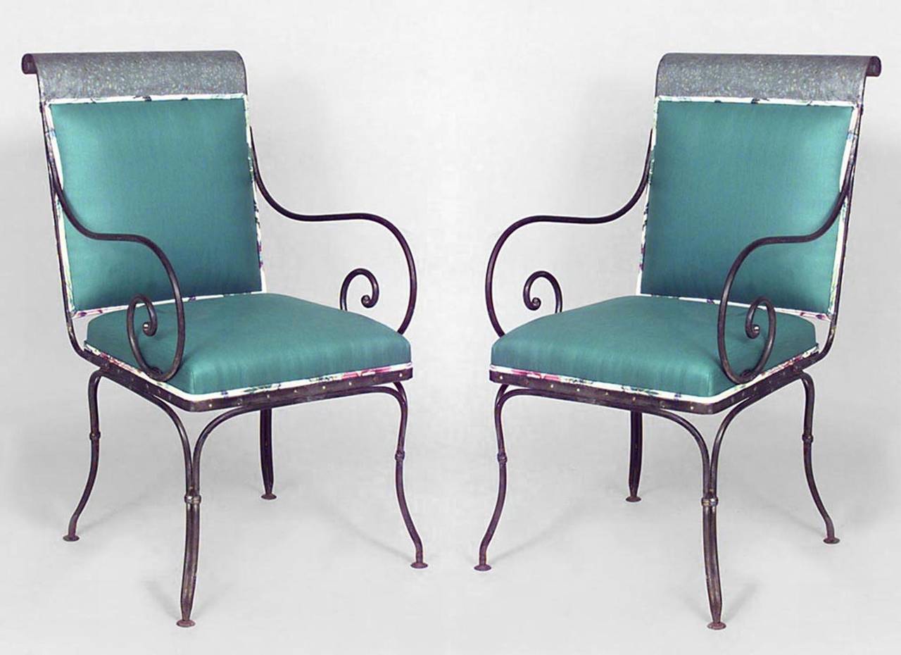 Pair of twentieth century French outdoor steel sleigh back arm chairs with scroll design arms and floral-upholstered seats and backs.