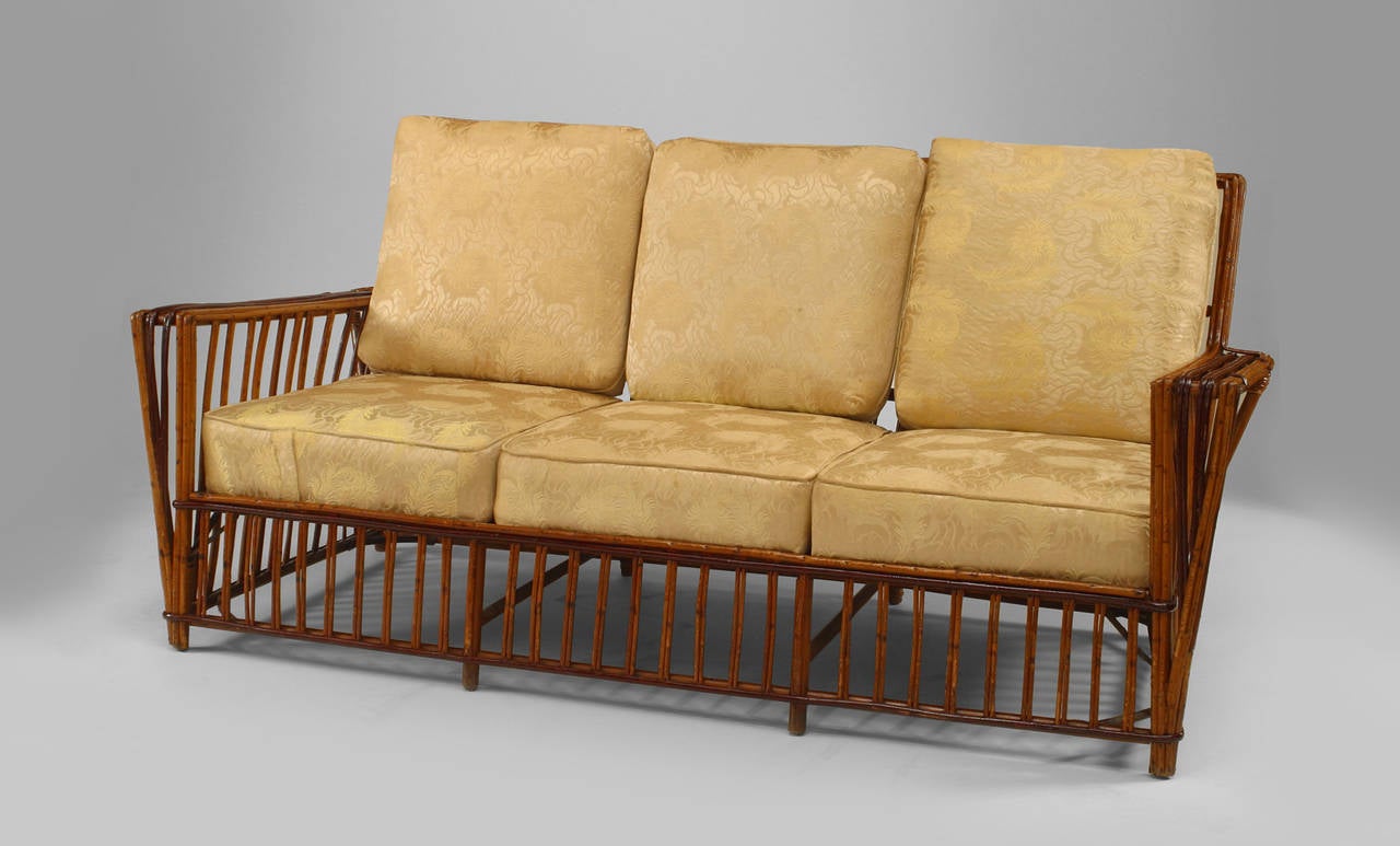 American Art Deco five piece salon set including one settee and four armchairs. The chairs are composed of natural split reeds decorated and trimmed
with red paint and wrapped wicker with square backs and cushions. 

Settee measures 66.5
