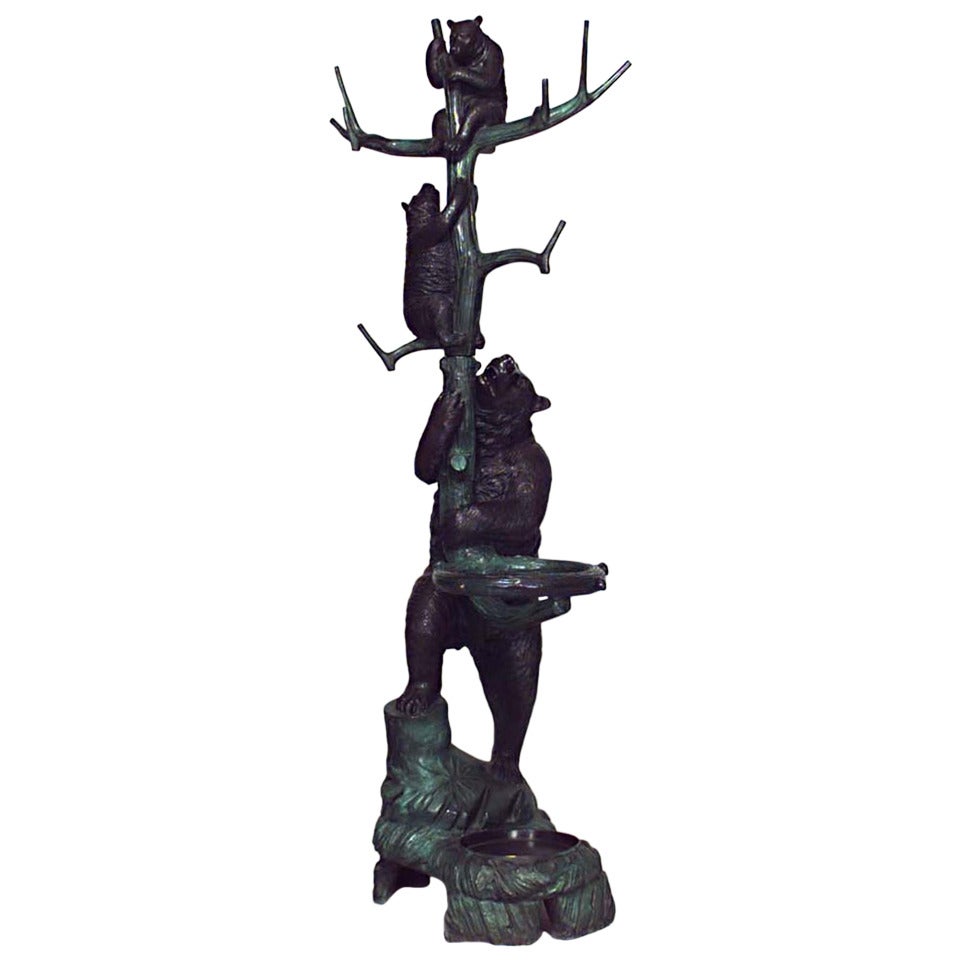 Twentieth century Black Forest style rustic bronze hatrack or umbrella stand featuring a bear standing upon an outcropping and supporting a trunk with two smaller climbing bears.