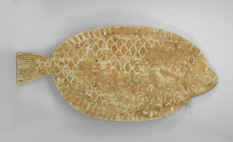 Turn of the century American country style trade sign carved in the form of a monumental flounder. The sculpture's light wooden medium retains vestiges of white paint, which serve to highlight the fish's somewhat stylized anatomy.