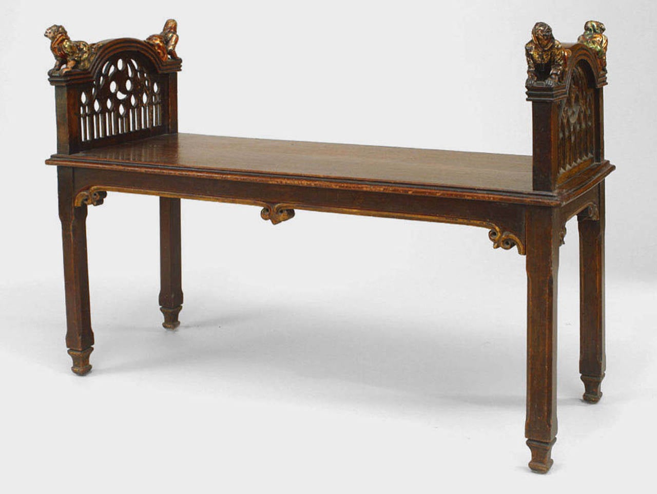 Nineteenth century English Gothic Revival walnut bench with filigree-carved sides and four polychromed reclining dwarf figures on each arm.