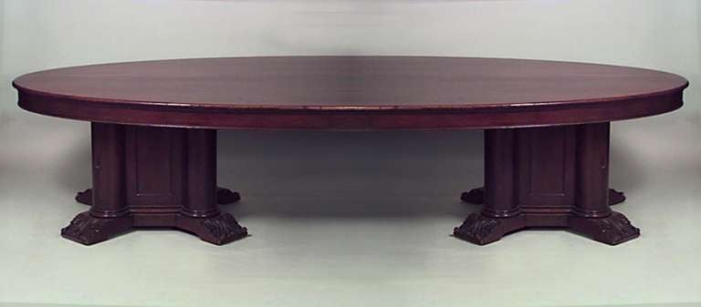 19th century English conference table composed of mahogany with an oval top resting upon two bases comprised of four composite columns.