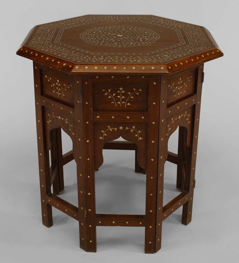 Nineteenth century Moorish style shaped taboret composed of teak with an octagonal top decorated with Islamic-inspired inlaid bone and silvered brass designs above a folding base.