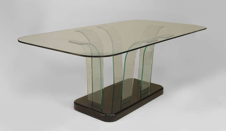 American Mid-Century Art Moderne (1940s) dining table with a large glass top with rounded corners resting on 6 bent glass supports on an ebonized rectangular base (MODERNIZE)
