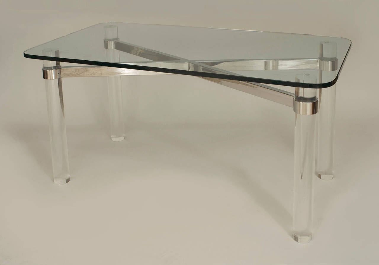 American Post-War Design rectangular center table with 4 cylindrical Lucite legs connected with a chrome stretcher under a glass top (PACE).

