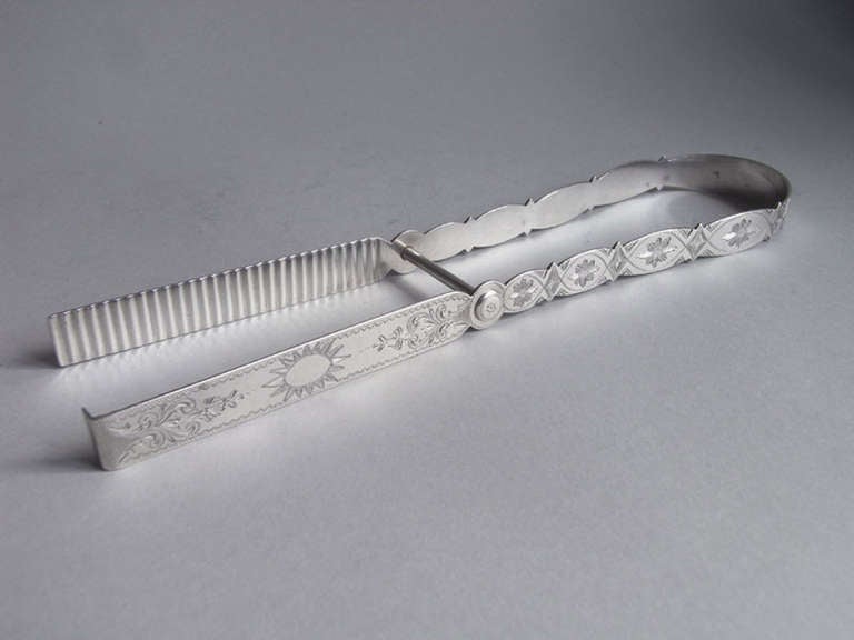 Bateman Family. A very rare pair of George III Asparagus Tongs made in London in 1800 by Peter, Ann & William Bateman.
This very unusual pair of Tongs have shaped arms which are beautifully engraved with flower heads in ovals, foliate scroll work