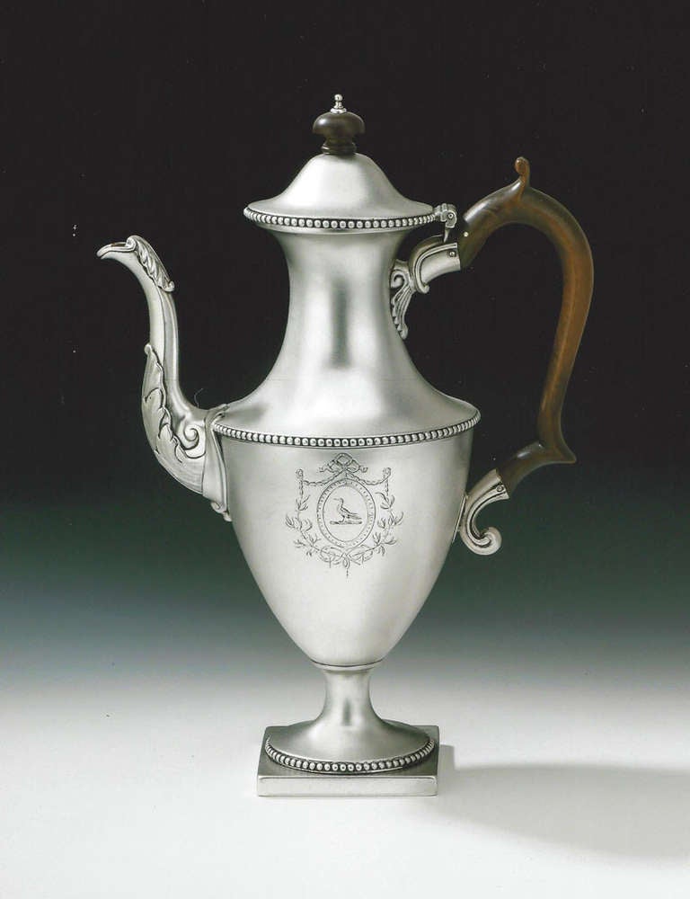 A very fine George III Neo-Classical Coffee Pot made in London in 1774 by John Carter II.
The Coffee Pot stands on a square pedestal foot which is decorated with a circular band of beading. The vase shaped main body also displays a band of bold