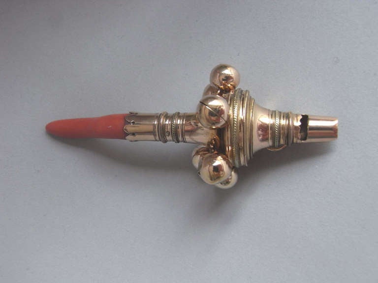 A very fine George III two colour 18 carat gold Baby's Rattle and Teether made in London in 1802 

The Rattle has a bellied form and six bell and ring attachments. The turned gold main body displays three vari-colour gold husk and guilloche bands.
