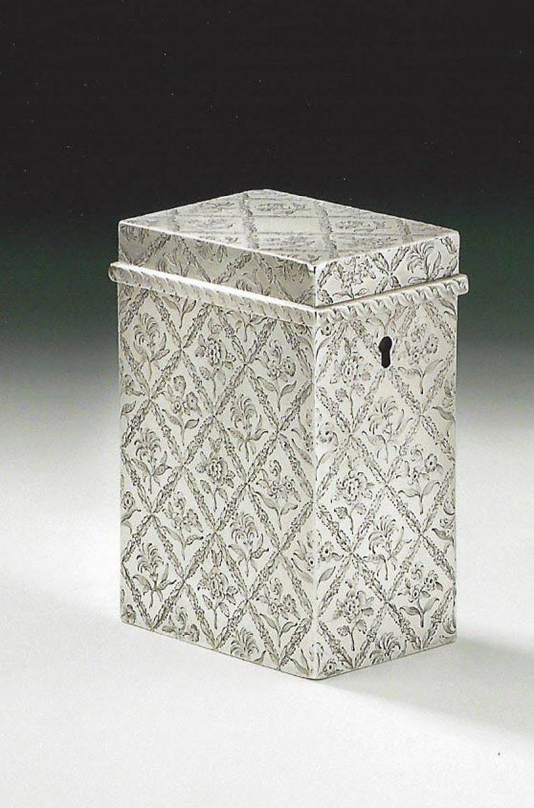The tea caddy is oblong in form and display a protruding upper band which is engraved with twisted ropework designs. The rest of the main body is beautifully engraved, to the highest standard, with diamond motifs containing a floral sprig. It is