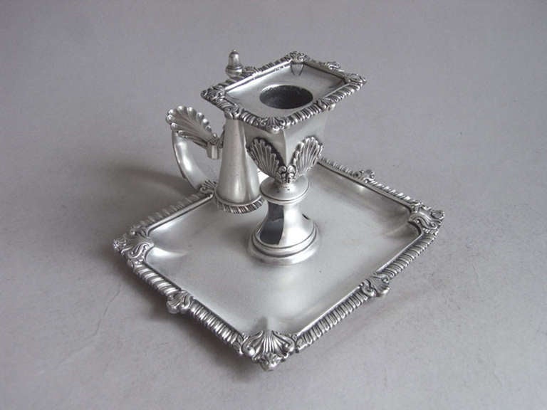 The Chambersticks unusually have a square base, rather than the more usual circular style. The outside border is decorated with gadrooning and anthemion motifs, in addition to Rococo shells. The main shaft rises to a square socket decorated with