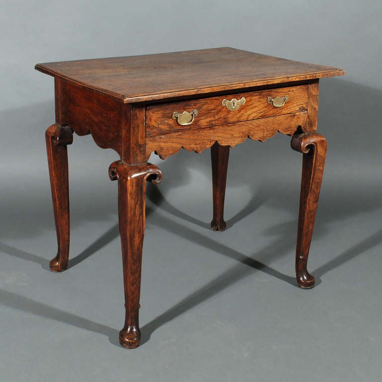 A George I single drawer side table, the moulded top above a shaped frieze, the whole on four heavy cabriole legs featuring shepherds crook carved decoration terminating in cloven hoof like pad feet.