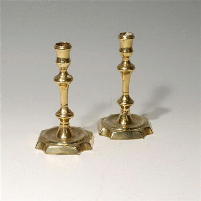 Pair George II brass candlesticks - square bases with re-entrant corners..