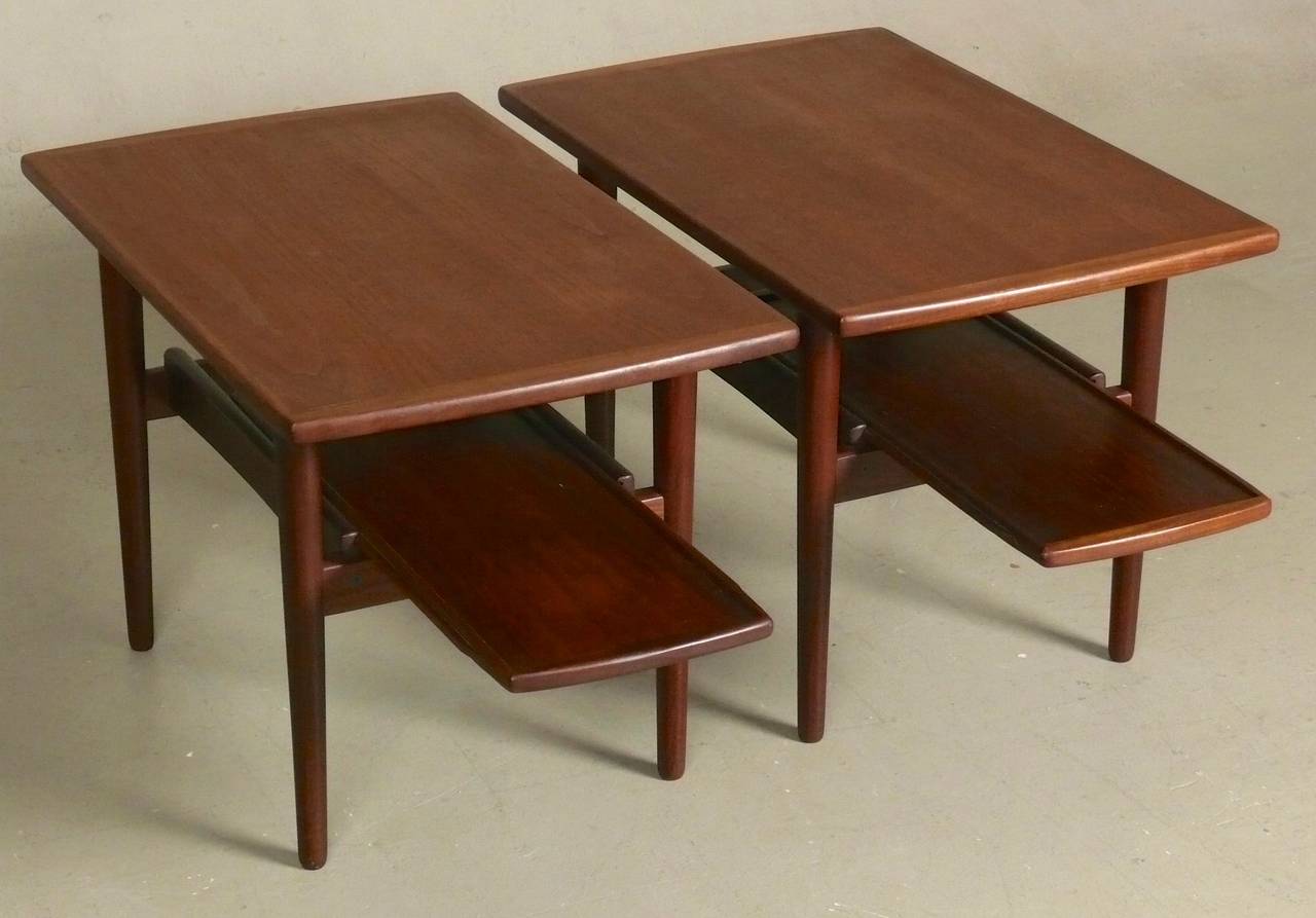 Pair of late 1950s Danish modern side tables with lower pull-out magazine shelf and simple tapered legs by Bramin Mobler, in beautiful restored condition.