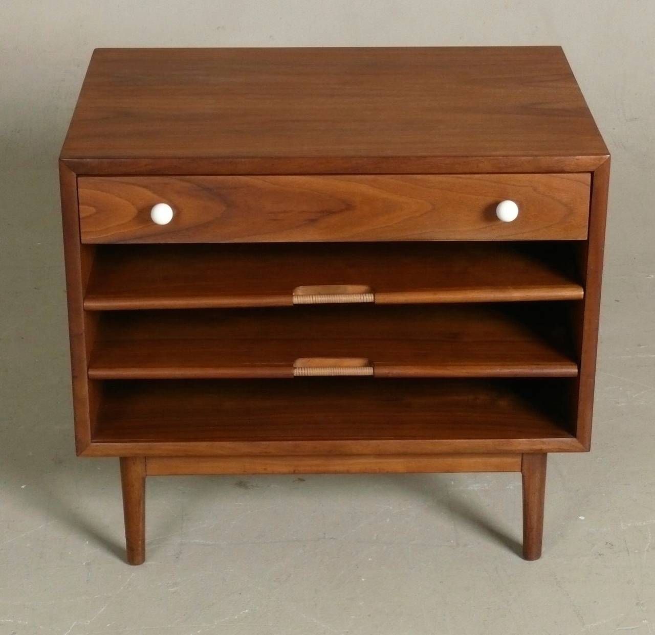 Rare example of Kipp Stewart's walnut magazine table for his Declaration line by Drexel, c. 1962.  Top drawer has original porcelain pulls, below are 2 pull out leaves to keep magazines sorted, each with a integrated, cane wrapped pull.  Would serve