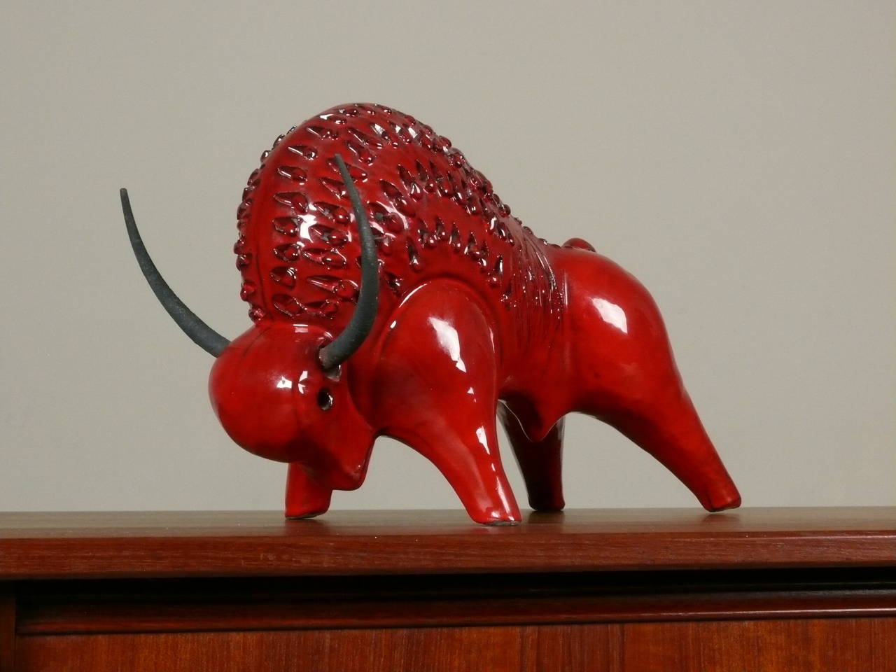 Large ceramic and steel bull by Alvino Bagni for Raymor, Italy.  The stylized stoneware figure is detailed with incised design work and rich red glaze treatment.