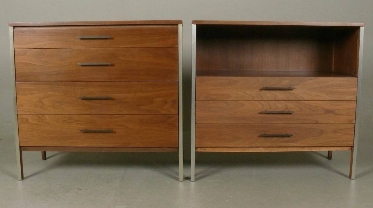 Pair of large scale walnut with brushed aluminum trim bedside tables or cabinets designed by Paul McCobb for Calvin Furniture, 1950s.  One features four drawers while the second features three drawers and an open shelf.  Refinished. Price indicated