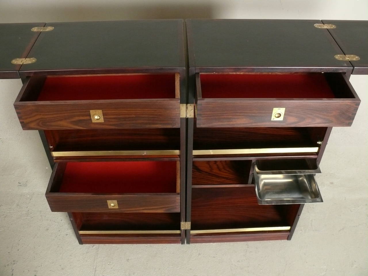 1960s Rosewood folding bar unit designed for Skovby, Denmark in beautiful condition.  Compact folding cube opens to a stunning rosewood dry bar with brass accents, drawers for storage, and stainless condiment trays.  Stainless trays marked Stelton,