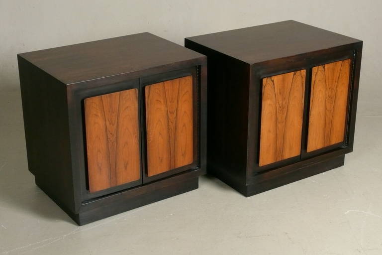 Pair of C.1970 dark stained walnut nightstands with over sized book matched rosewood panel pulls by Henredon. Each has an adjustable shelf & a 3 socket electrical outlet inside with a cord that runs out of the back. Restored tops.