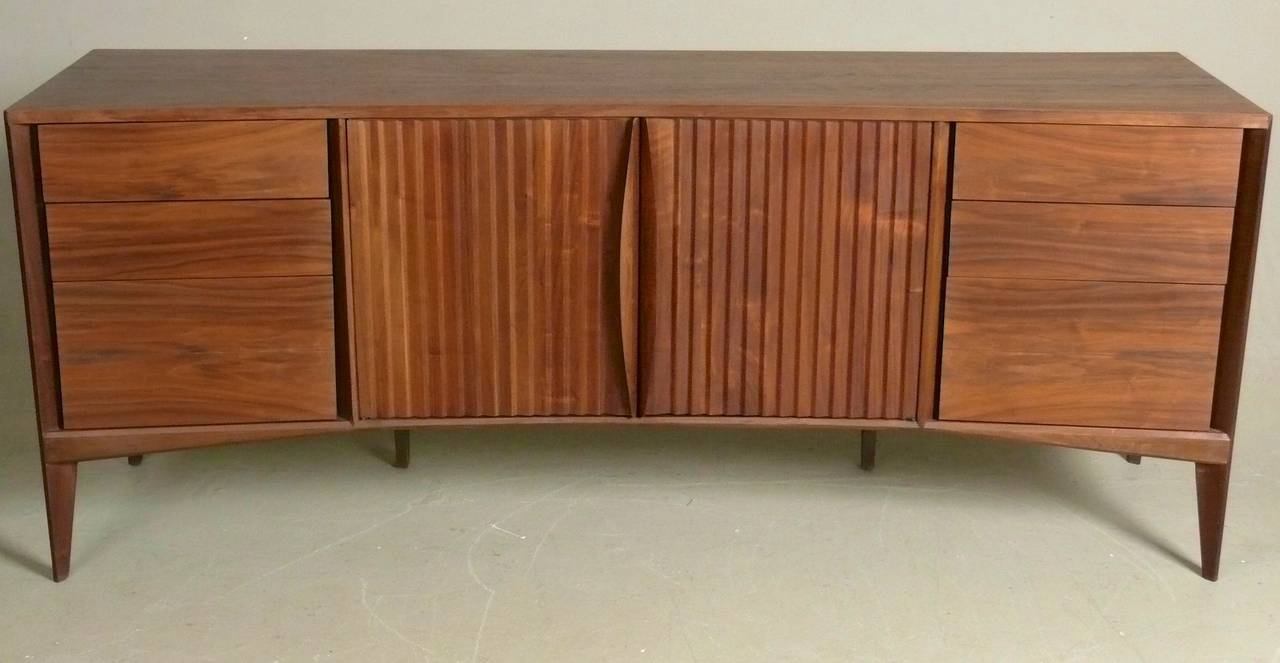 1960s walnut dresser with reverse bowfront and simple, sculptural detail on legs and drawer fronts, attributed to Edmund Spence.