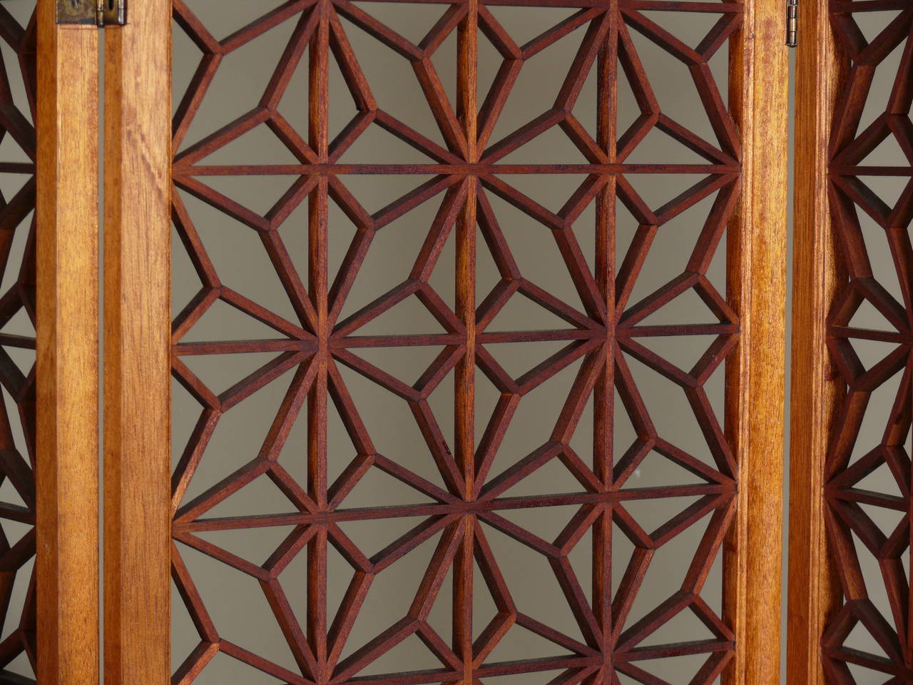 Stunning teak folding screen with geometric pattern.  Bi-fold hinges allow for a variety of configurations and lengths.  Each panel measures 17.5