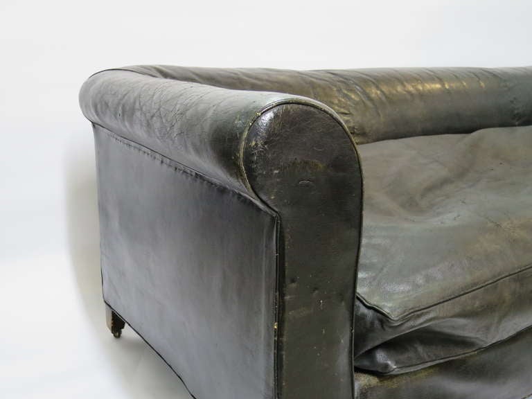 Handsome sofa by Maison Carlhian in black leather with superlative patina from France, 1920s. Rolled arm details, tuxedo even back, single plush down cushion on oak feet with original casters.

Carlhian, 22 Place Vendôm, Paris.