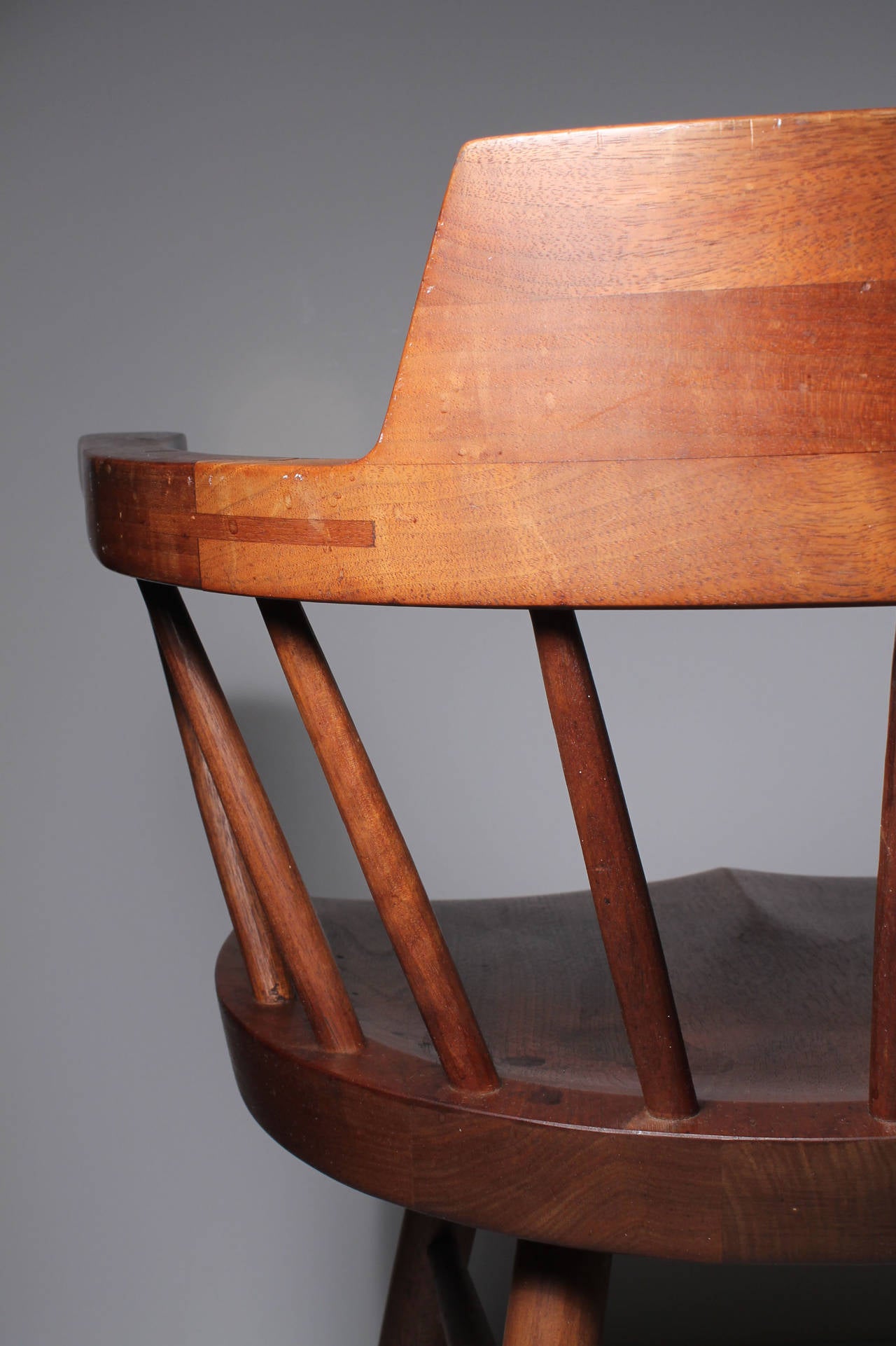 Pair of dramatic STUDIO Nakashima Captains Chairs
Handcarved spindels. Mortis and Tendon design connection to arm. 
A beautiful design form of the captains chair.  
nice construction pencil marks to underside of the chair and handwritten 