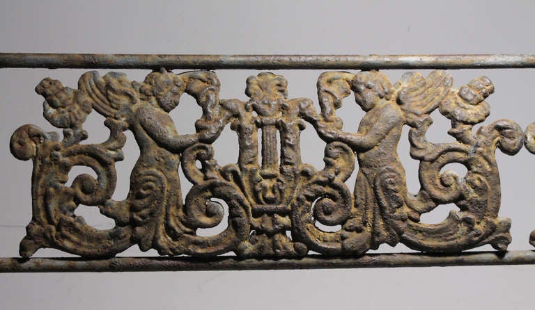 A GERMAN CAST-IRON BENCH AFTER THE DESIGN BY KARL FRIEDRICH SCHINKEL, 19TH CENTURY 

This is a nice early example with excellent patina.

The horizontal pierced splat cast with lyres flanked by winged putti and foliate scrolls, the curved arms